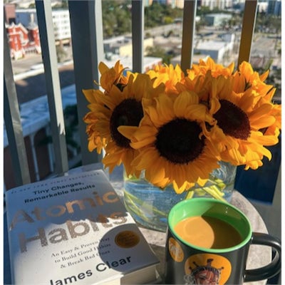 Atomic Habits Book on a table with flowers